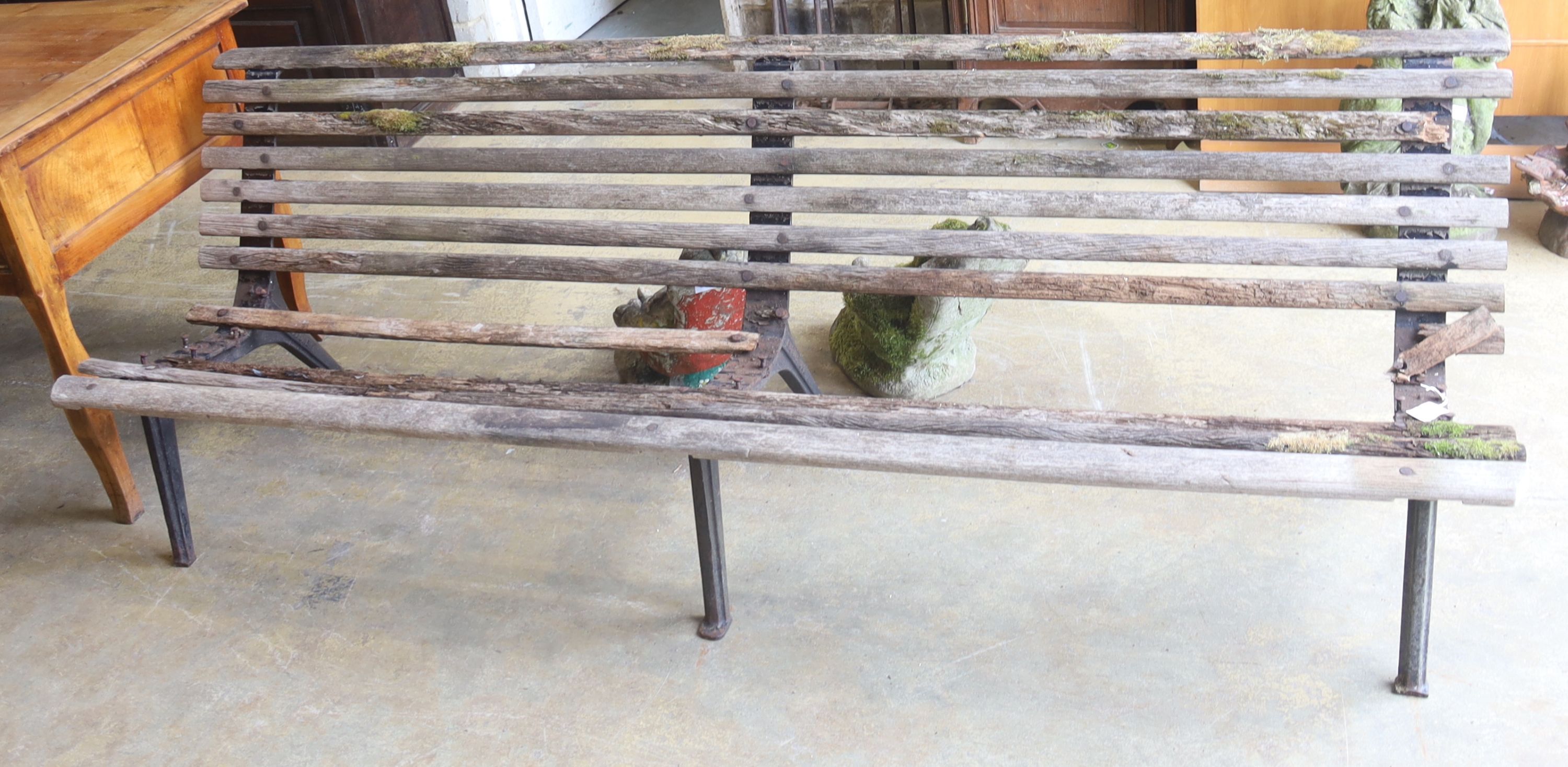 A slatted wood garden bench marked L M Furniture (in need of repair), length 244cm, depth 70cm, height 77cm